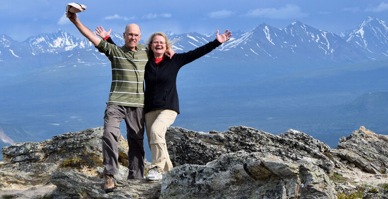 Older couple posing atop a mountain